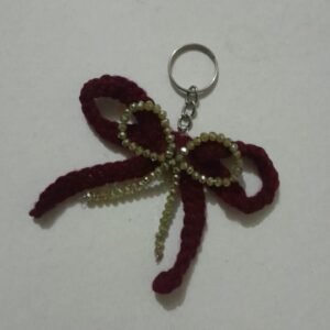 Handmade crochet bow keychain with decorative beads.